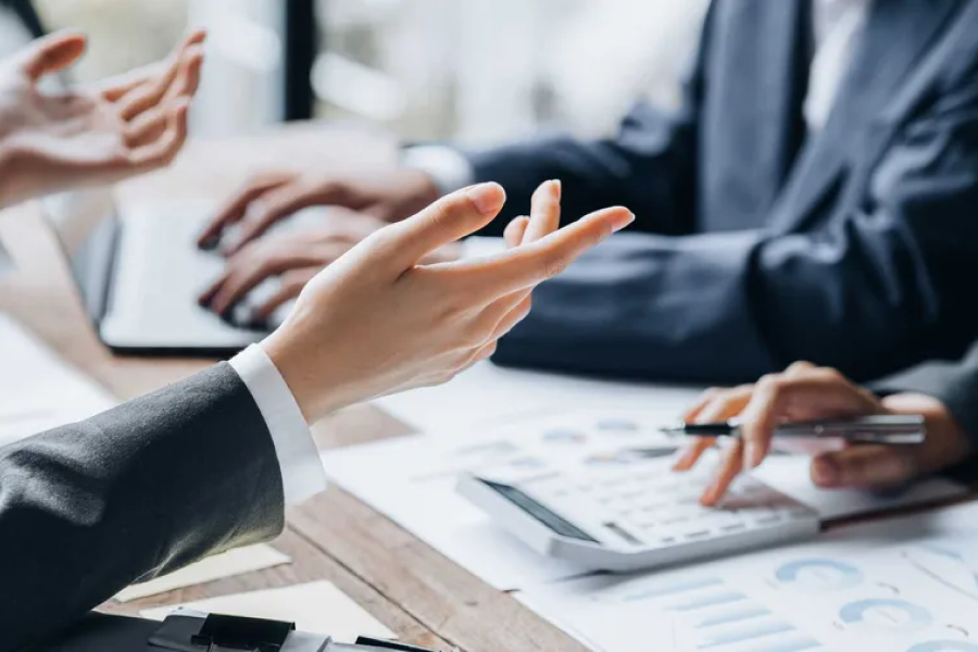 a cropped photo of arms from a group of people having a meeting